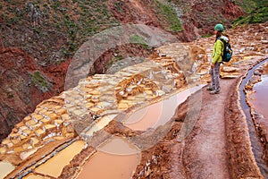 Young woman standing at Salinas de Maras salt evaporation ponds