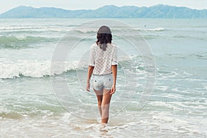 Young woman standing by sea and looking to horizon