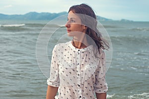 Young woman standing by sea and looking to horizon