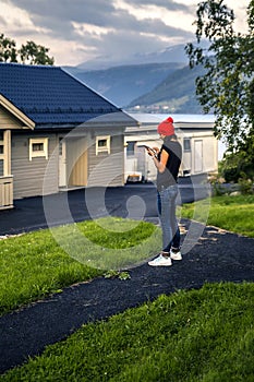 Young woman standing and searching something in the mobile phone