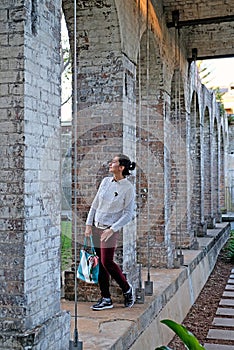 A young woman standing among the stone columns in Paddington Reservoir Gardens, Sydney, Australia