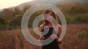 Young woman standing on the straw field and smiling