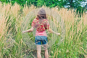 Young woman standing in tall grass