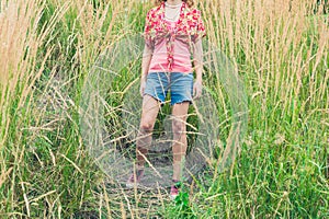 Young woman standing in tall grass