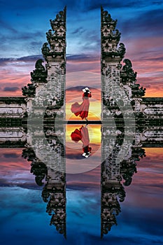 Young woman standing in temple gates at Lempuyang Luhur temple in Bali, Indonesia photo
