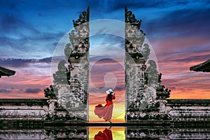 Young woman standing in temple gates at Lempuyang Luhur temple in Bali, Indonesia photo
