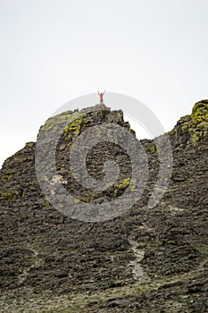 Young woman standing on the top of cliff