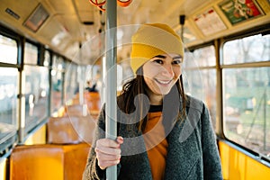 Young woman standing in a wagon of a driving tramway. Transportation, travel and lifestyle concept