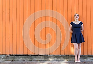 Young woman standing on a wall thinking