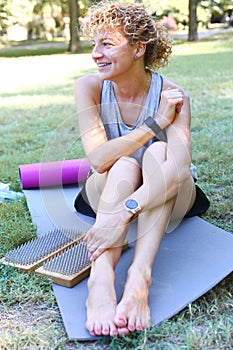 young woman after standing on yoga nail desk sadhu closeup photo on green grass background