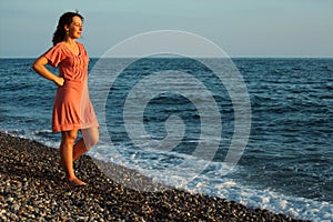 Young woman stands ashore of sea