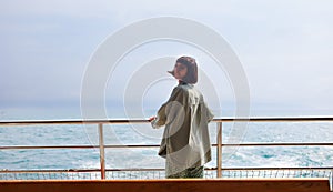 young woman stands on the deck of a cruise ship and enjoys the journey. woman on a yacht on vacation, vacation and travel. A young