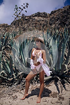 Young woman stands among desert near agaves