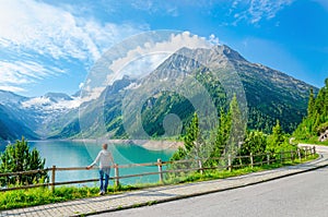 Young woman stands by mountain lake , Austria