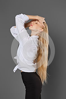 A young woman stands in profile showing her long hair