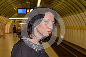 Young woman staring anxiously down the tracks