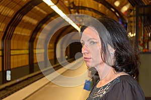 Young woman staring anxiously down the tracks