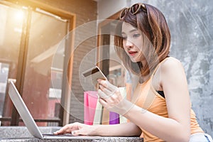 Young woman stay at home using laptop computer shopping online with credit card