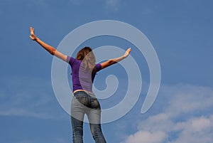 Young woman staying with raised hands