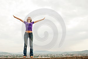 Young woman staying with raised hands