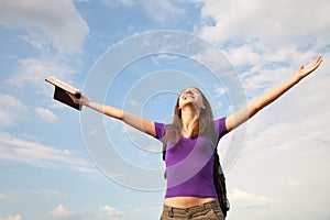 Young woman staying with raised hands photo