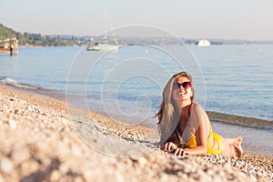 Young woman staying on the shore of Garda lake, Italy