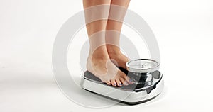 Young woman stepping on an old fashioned scale