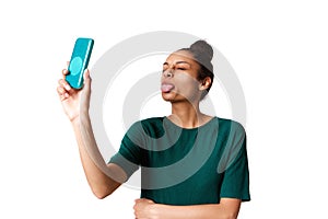 Young woman sticking out her tongue and taking selfie