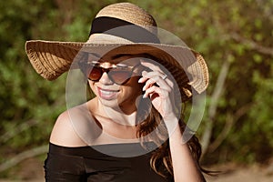 Young woman in straw hat close-up in sunglasses