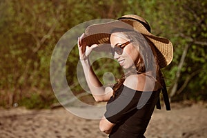 Young woman in straw hat close-up in sunglasses