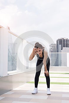 Young woman strengths gasping feeling pleasantly tired after jogging photo