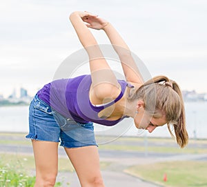 Young woman stretches.