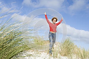 Young woman stretching amongst dunes