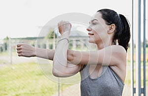 Young woman stretching body after jogging, female stretches body. Portrait of beautiful girl close-up exercising in the