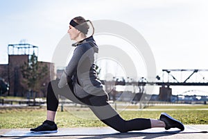 Young woman stretching her quadriceps muscles by grabbing her ankle