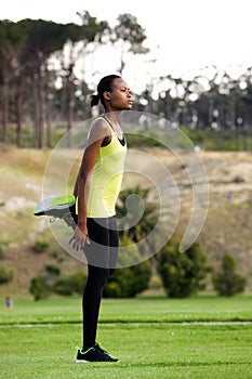 Young woman stretching leg muscles outdoors