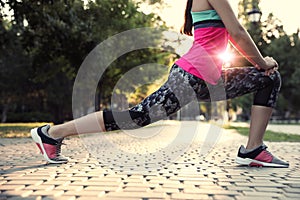 Young woman stretching before morning run in park, closeup