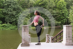 Young woman stretching outdoors in the afternoon.