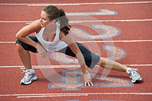 Young Woman Stretching on Running Track