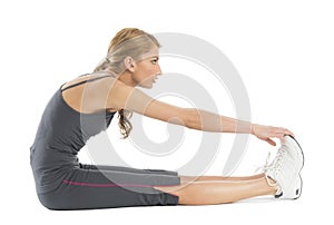 Young Woman Stretching To Touch Her Toes