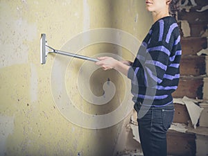 Young woman stripping wallpaper