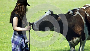 Young woman stroking a cow. Ð¡ontented cow