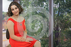 young woman student in office defocused window background businesswoman workplace curly hair brunette