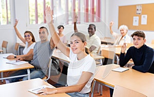 Young woman student raising her hand and smiling