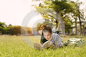 Young woman student reading book in university