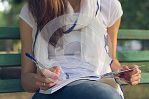 Young woman student sitting on a bench in the Park