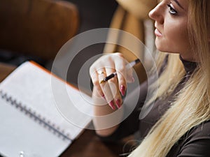 Young woman student of the University. Preparing exam and learning lessons in public library.