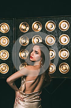 Young woman studio fashion portrait. Dark golden colors.