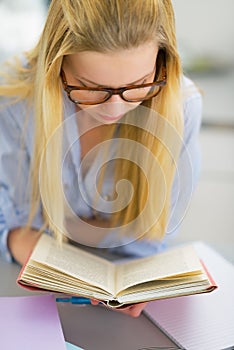 Young woman studying in kitchen