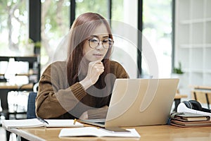 Young woman studying or working online using laptop.